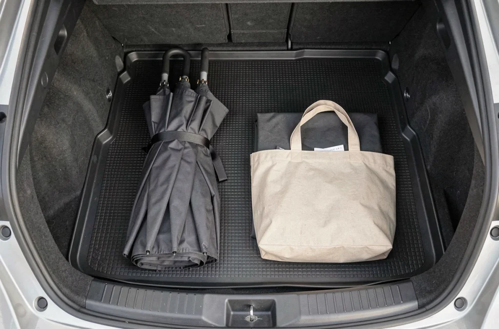 Vue du dessus du coffre Toyota C-HR avec une poussette compacte pliée et un sac de courses